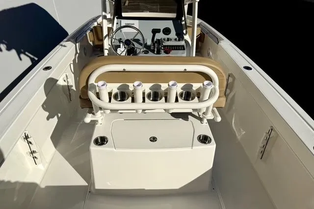 Slide: The Image of 2026 Bayliner Trophy T22CC boat interior with steering console and rod holders. - 24