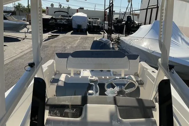 Slide: The Image of 2026 Bayliner Trophy T22CC boat, front view, parked outdoors near buildings. - 7