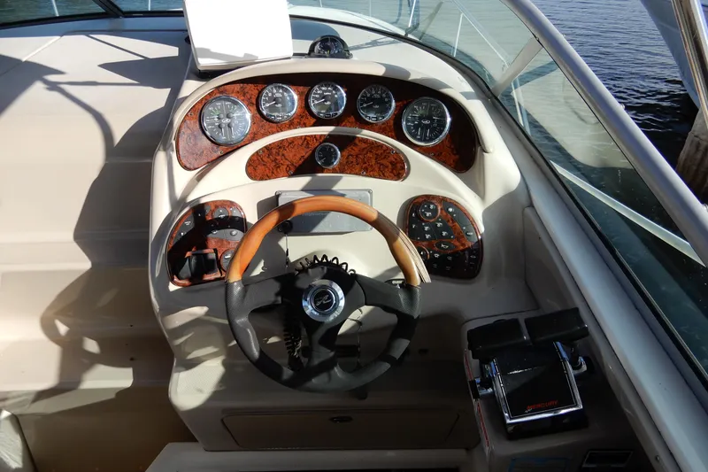 Slide: The Image of 2004 Sea Ray 280 Sundancer dashboard with wood accents and steering wheel. - 14