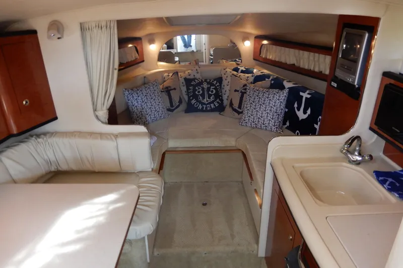 Slide: The Image of 2004 Sea Ray 280 Sundancer cabin interior with nautical-themed decor and kitchenette. - 21