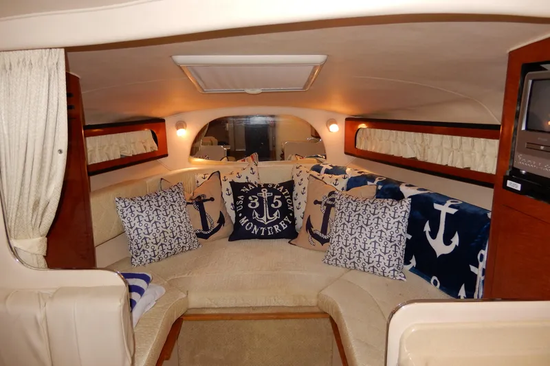 Slide: The Image of Interior of 2004 Sea Ray 280 Sundancer with nautical-themed cushions and cozy seating area. - 23