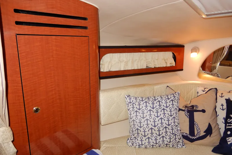 Slide: The Image of Interior of 2004 Sea Ray 280 Sundancer with nautical-themed pillows and wood cabinetry. - 24