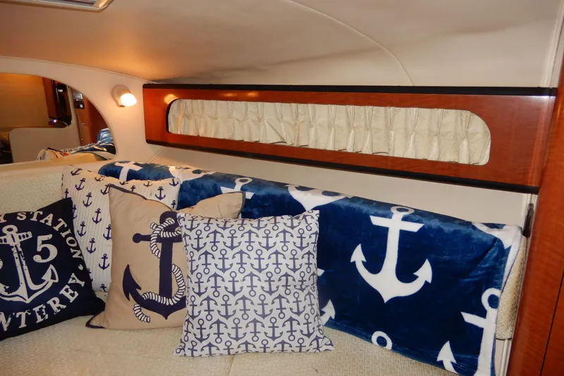 Slide: The Image of Interior of 2004 Sea Ray 280 Sundancer with nautical-themed pillows and cozy seating. - 25
