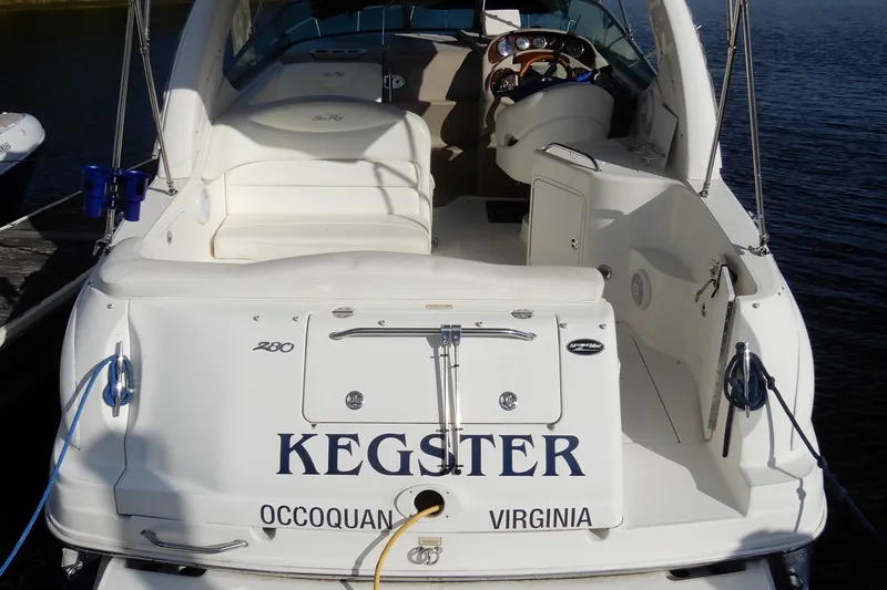 Slide: The Image of 2004 Sea Ray 280 Sundancer boat docked, rear view with "KEGSTER" name visible. - 4