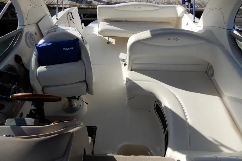 Slide: The Image of 2004 Sea Ray 280 Sundancer boat interior with white seating and steering wheel. - 5