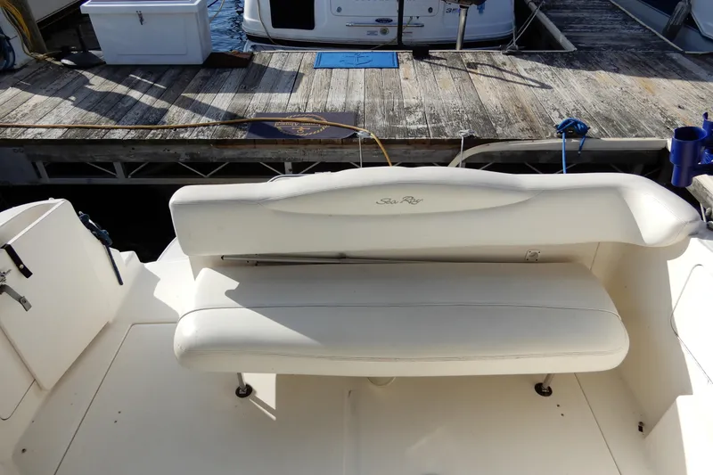Slide: The Image of 2004 Sea Ray 280 Sundancer boat interior with white seating at dock. - 7