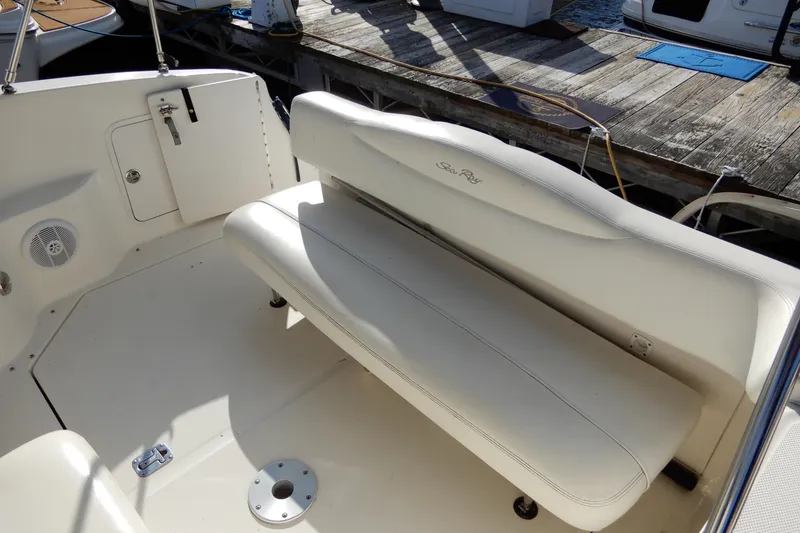 Slide: The Image of 2004 Sea Ray 280 Sundancer boat interior with white seating and dock view. - 8