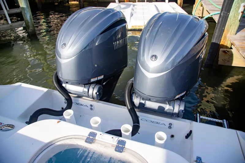Slide: The Image of 2023 Cobia 280 Center Console with dual Yamaha outboard engines at dock. - 10