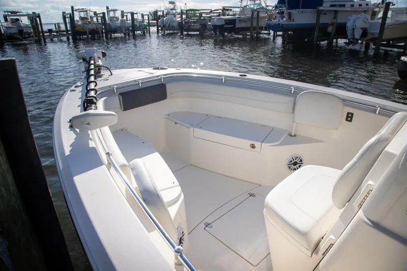 Slide: The Image of 2023 Cobia 280 Center Console boat interior at marina, featuring spacious seating and storage. - 15