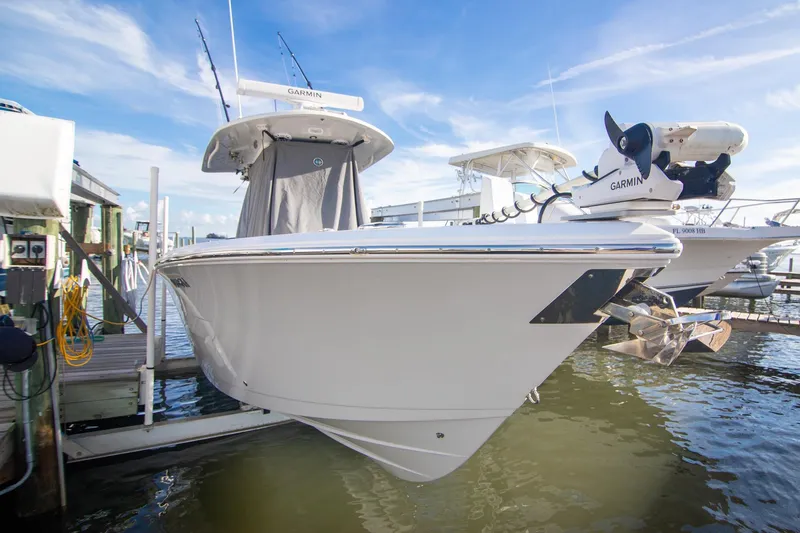 Slide: The Image of 2023 Cobia 280 Center Console boat docked, featuring Garmin equipment, under a clear blue sky. - 19