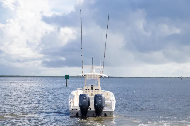 Slide: The Image of 2023 Cobia 280 Center Console boat on open water under cloudy sky. - 2