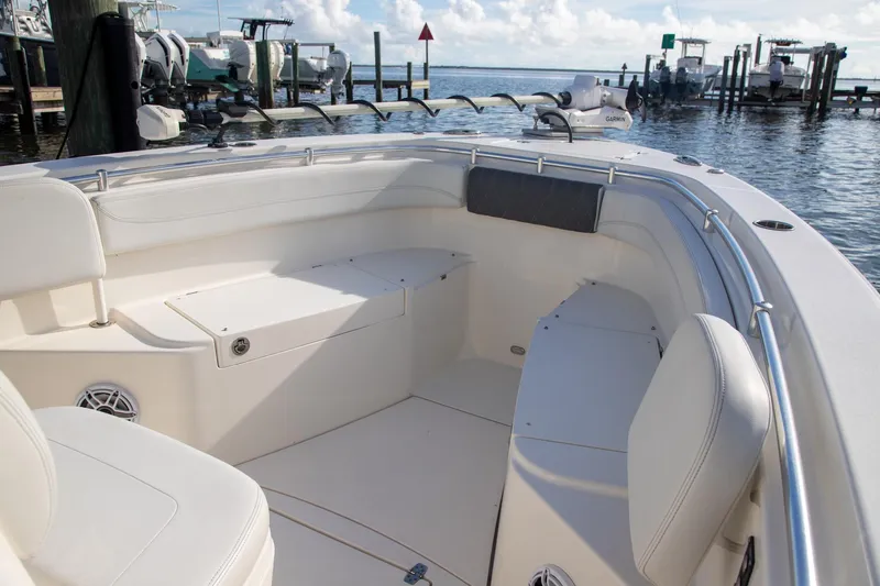 Slide: The Image of 2023 Cobia 280 Center Console boat interior with seating, docked by the water. - 23