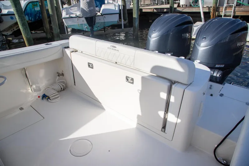 Slide: The Image of 2023 Cobia 280 Center Console boat interior with dual engines and seating area. - 24