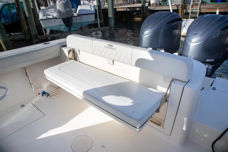 Slide: The Image of 2023 Cobia 280 Center Console boat with cushioned seating and dual outboard motors. - 25