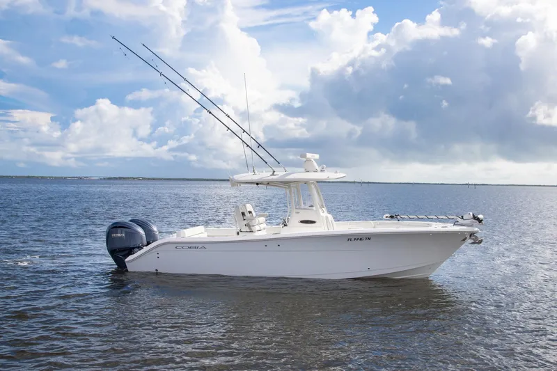 Slide: The Image of 2023 Cobia 280 Center Console boat on calm water under a cloudy sky. - 3
