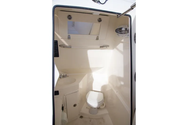 Slide: The Image of 2023 Cobia 280 Center Console boat interior with toilet and sink. - 30