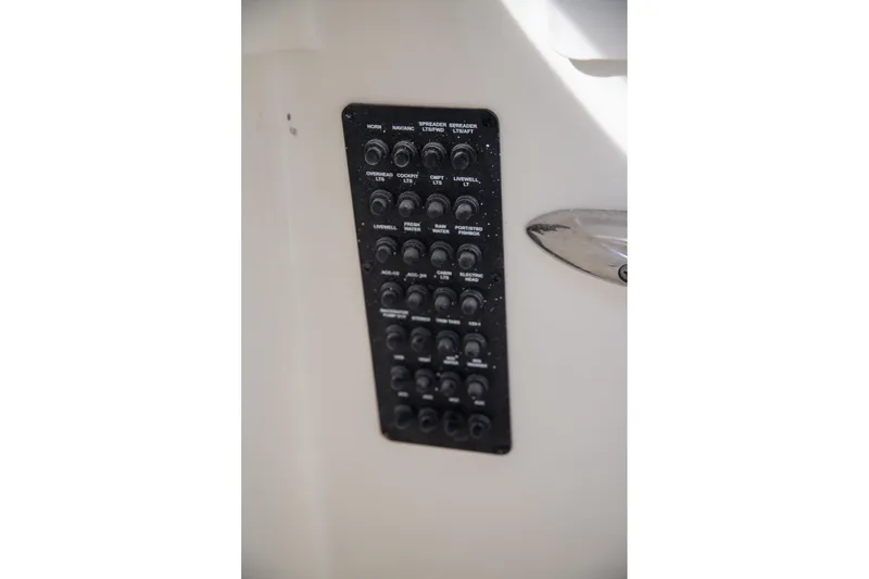 Slide: The Image of Control panel on 2023 Cobia 280 Center Console boat, featuring various switches. - 31