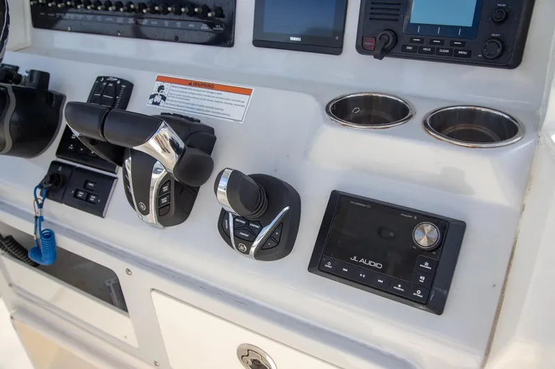 Slide: The Image of Control panel of 2023 Cobia 280 Center Console with audio system and cup holders. - 5