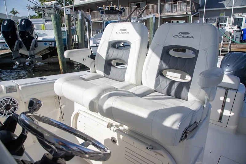 Slide: The Image of 2023 Cobia 280 Center Console boat with dual cushioned seats and steering wheel. - 7