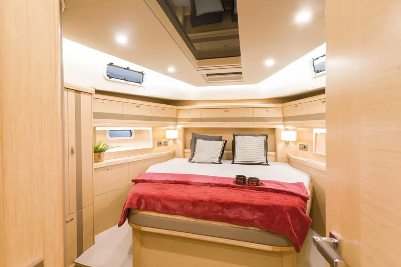 Slide: The Image of Das Bild zeigt eine luxuriöse Kabine mit einem großen Bett, Holzmöbeln und einem Oberlicht. - 23