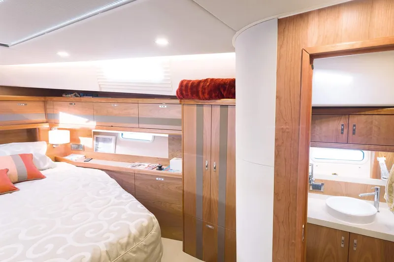 Slide: The Image of Das Bild zeigt eine luxuriöse Kabine mit einem großen Bett, Holzverkleidung und einem Badezimmer. - 24