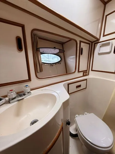 Slide: The Image of Compact bathroom with sink, toilet, and porthole window in a 1988 President Sedan. - 13