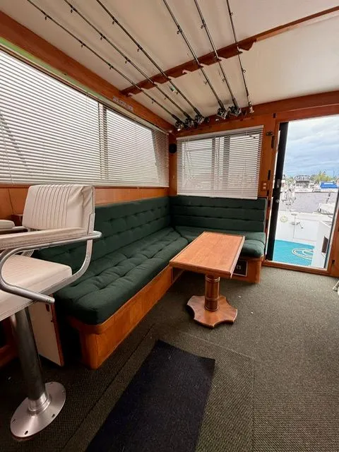 Slide: The Image of Cozy boat interior with green seating, fishing rods, and a view of the marina. - 6