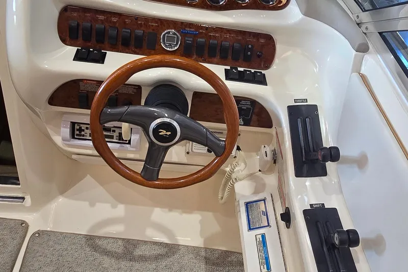 Slide: The Image of 1998 Sea Ray 280 Sun Sport helm with wood-accented steering wheel and control panel. - 15