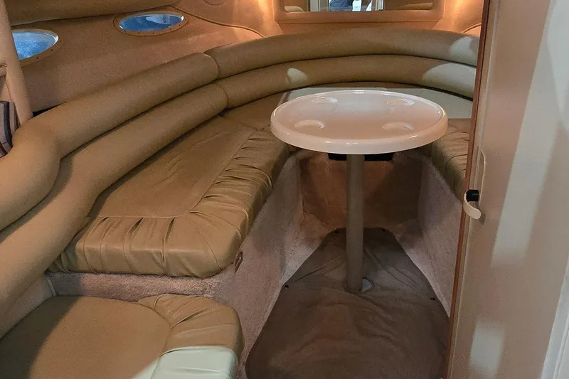 Slide: The Image of 1998 Sea Ray 280 Sun Sport cabin interior with beige seating and round table. - 20