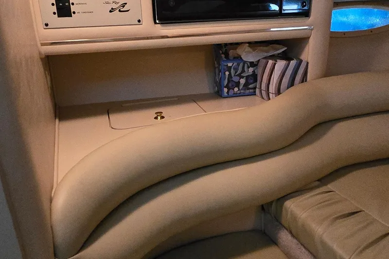 Slide: The Image of Interior of a 1998 Sea Ray 280 Sun Sport boat with beige seating and storage area. - 21