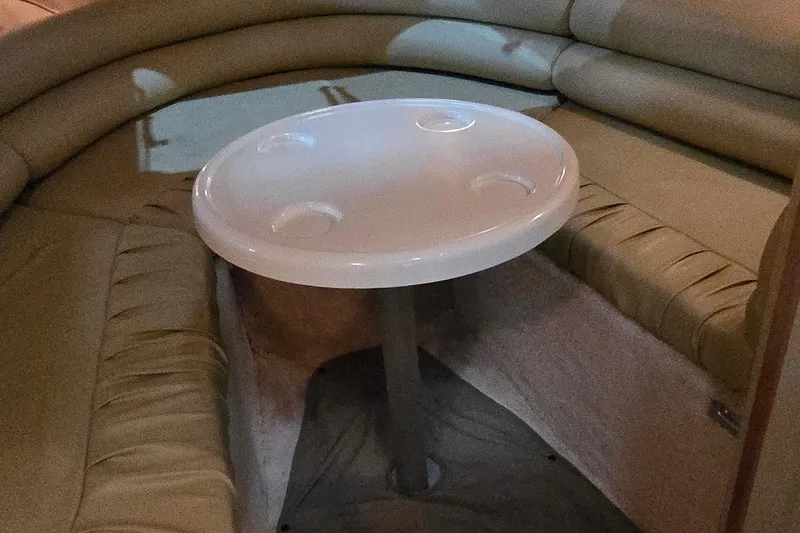 Slide: The Image of Interior of 1998 Sea Ray 280 Sun Sport with round table and cushioned seating. - 22