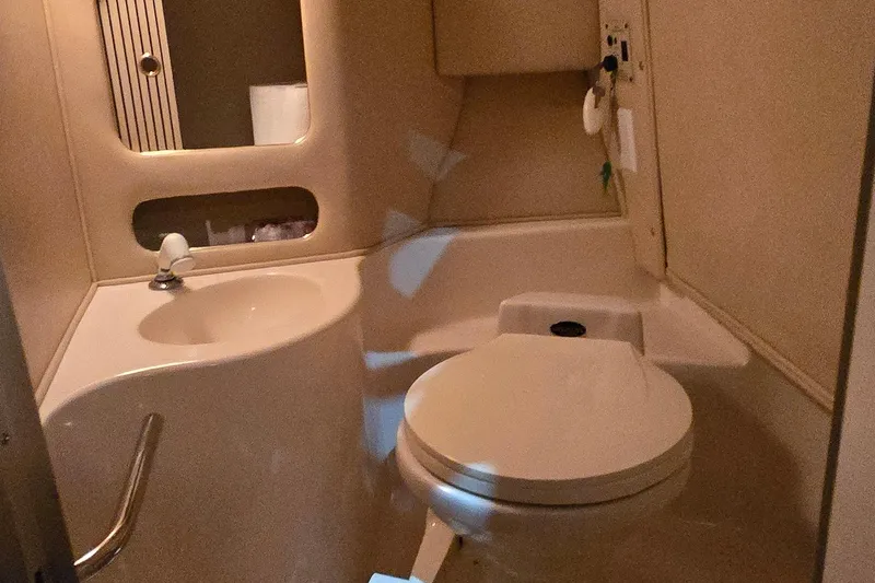 Slide: The Image of 1998 Sea Ray 280 Sun Sport boat bathroom with sink, toilet, and mirror. - 24