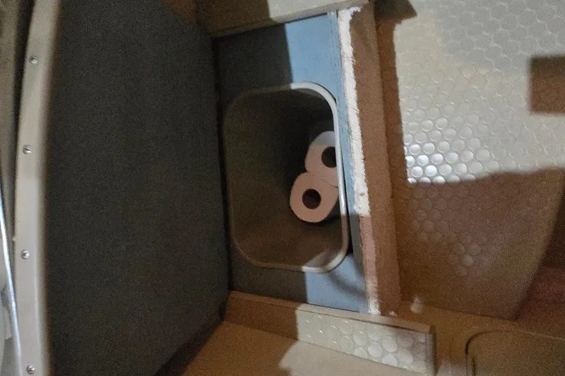 Slide: The Image of Storage compartment with toilet paper in a 1998 Sea Ray 280 Sun Sport boat. - 28