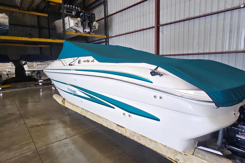 Slide: The Image of 1998 Sea Ray 280 Sun Sport boat with teal cover in storage facility. - 4