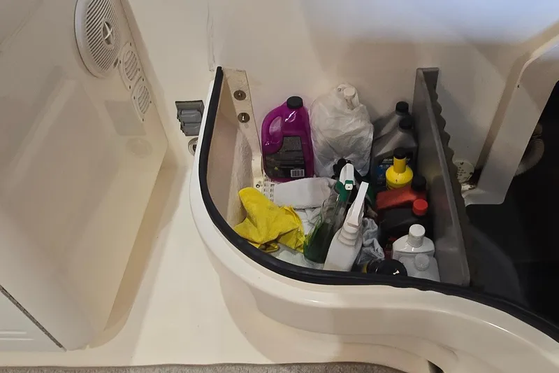 Slide: The Image of Storage compartment on a 1998 Sea Ray 280 Sun Sport with cleaning supplies and bottles. - 45