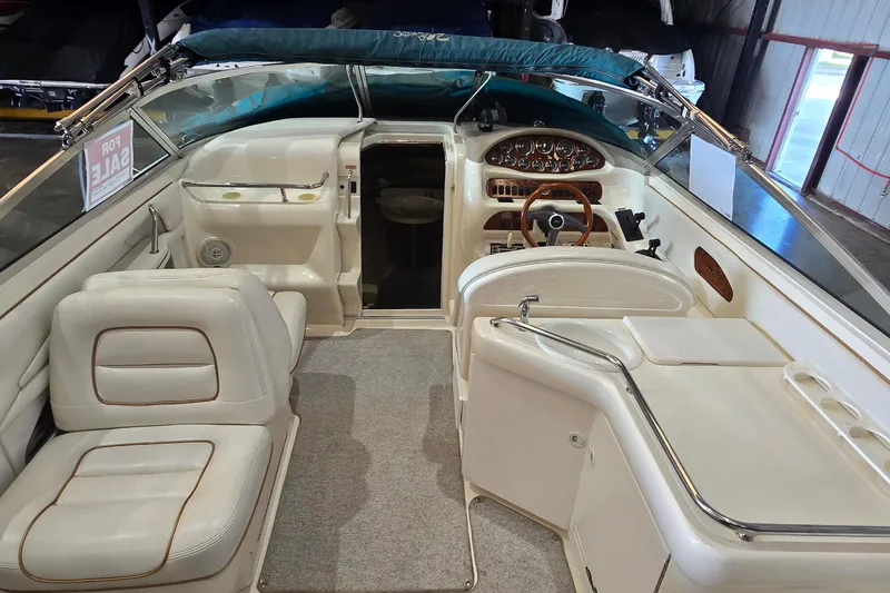 Slide: The Image of 1998 Sea Ray 280 Sun Sport boat interior with white seating and dashboard, for sale sign visible. - 8
