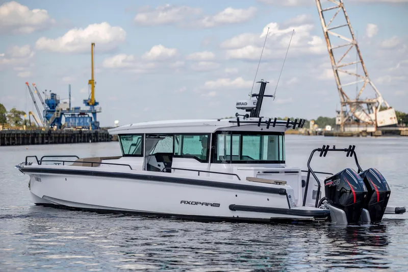 Slide: The Image of 2024 Axopar 37 XC boat on water with dual engines, industrial background. - 37