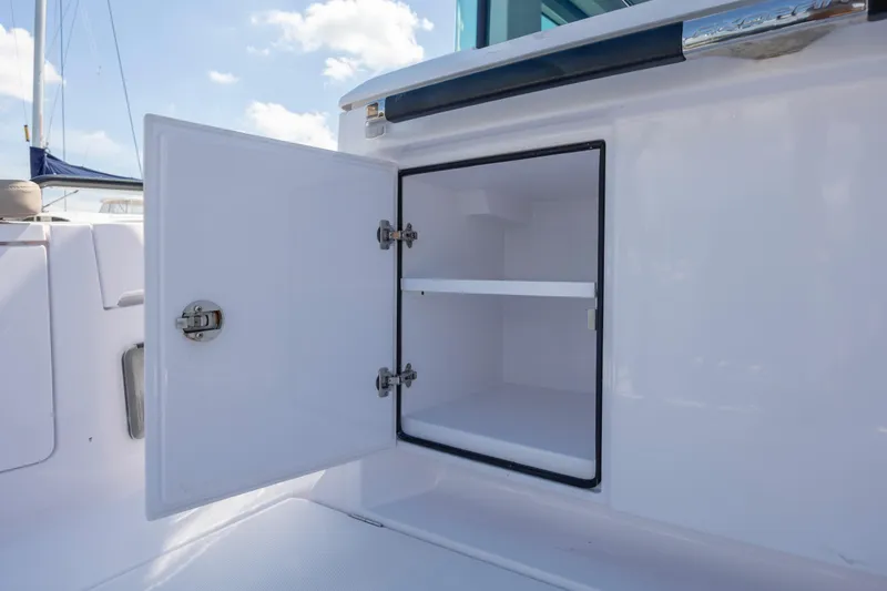 Slide: The Image of Open storage compartment on 2024 Axopar 37 XC boat, showcasing interior shelving. - 47