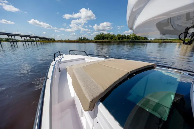 Slide: The Image of 2024 Axopar 37 XC boat on calm water, featuring a sunbed and scenic view. - 49