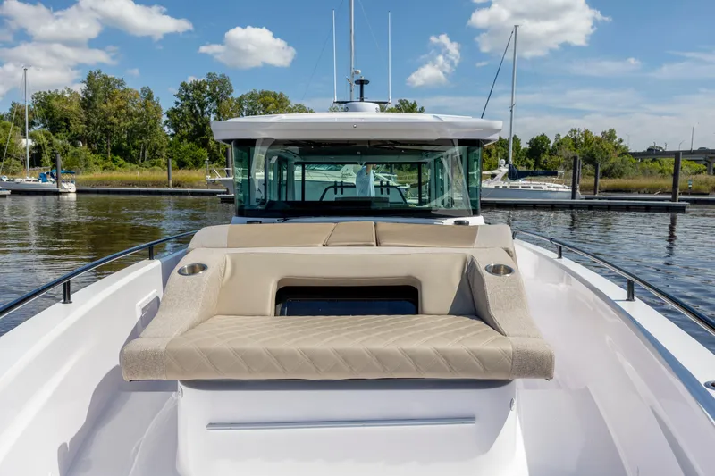 Slide: The Image of 2024 Axopar 37 XC boat with beige seating, docked on a sunny day. - 51