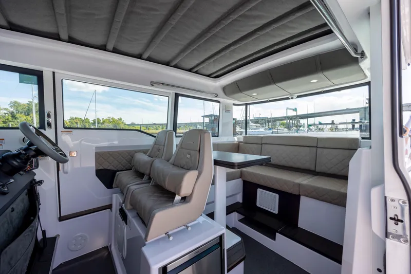 Slide: The Image of 2024 Axopar 37 XC interior with seating, table, and helm station. - 57