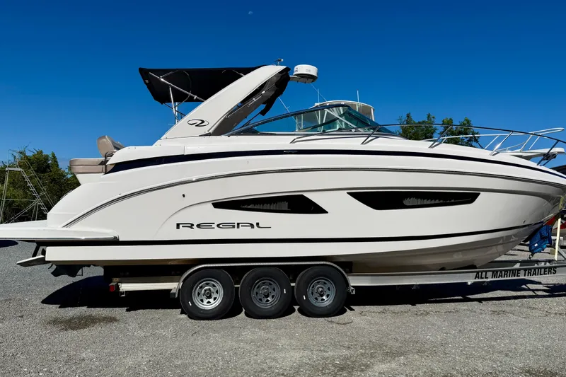 The Image of 2017 Regal 32 Express boat cruising on calm water, showcasing sleek design and modern features. - 0