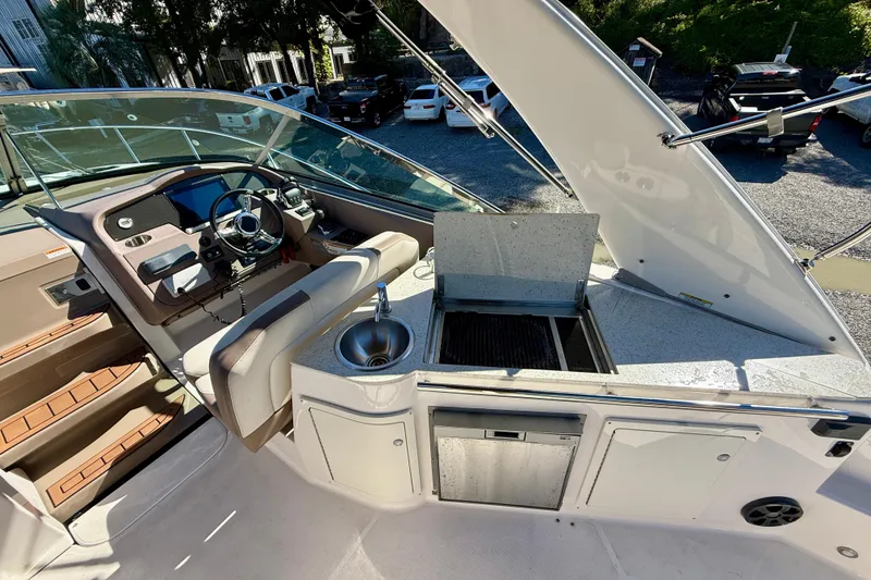 Slide: The Image of 2017 Regal 32 Express boat interior with seating, overlooking a serene waterfront view. - 10