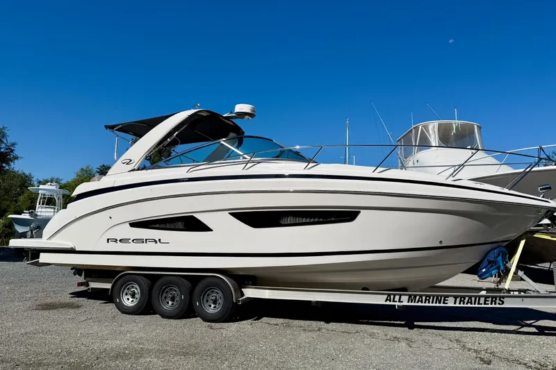 Slide: The Image of 2017 Regal 32 Express boat cruising on calm waters under a clear sky. - 2