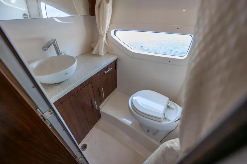 Slide: The Image of 2017 Regal 32 Express yacht bathroom with sink, toilet, and window view. - 28