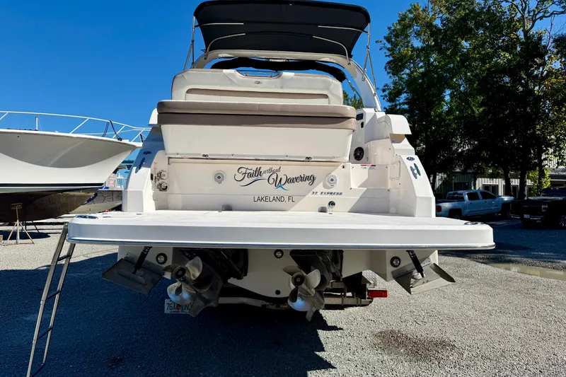 Slide: The Image of 2017 Regal 32 Express boat cruising on a calm river under a clear sky. - 4