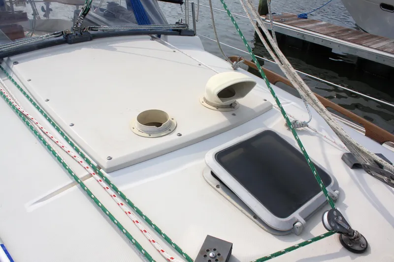 Slide: The Image of 1988 Pearson 31 sailboat deck with hatch, ropes, and fittings at dockside. - 11