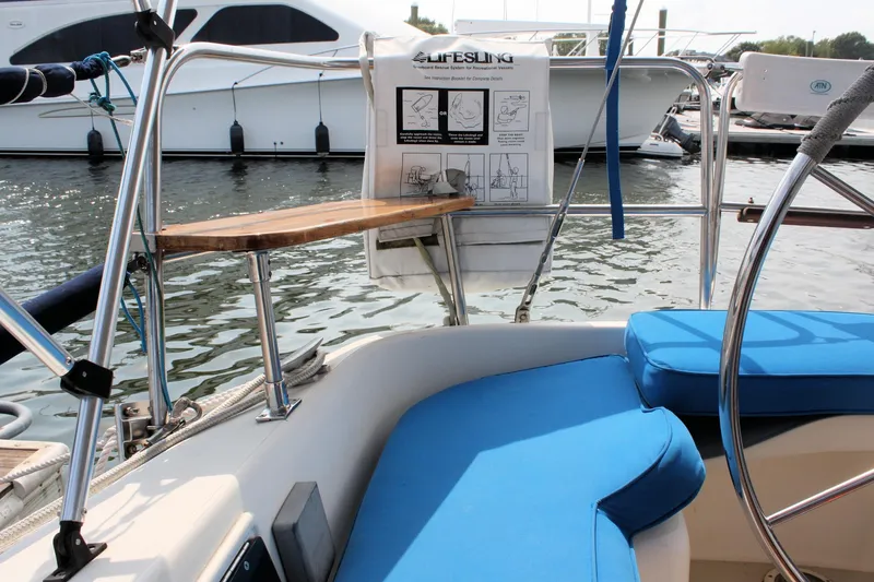 Slide: The Image of Cockpit of a 1988 Pearson 31 sailboat with blue cushions and safety instructions. - 13