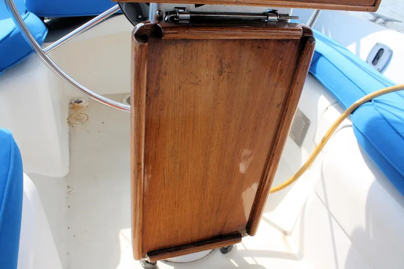 Slide: The Image of Cockpit of 1988 Pearson 31 sailboat with wooden table and blue cushions. - 15