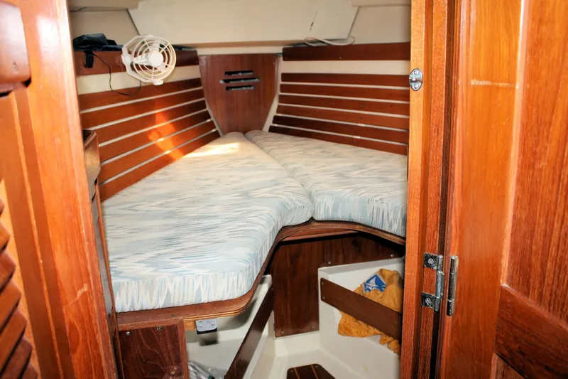 Slide: The Image of Cozy cabin interior of 1988 Pearson 31 sailboat with wooden finish and cushioned berth. - 23